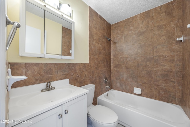 full bathroom with tiled shower / bath combo, a textured ceiling, toilet, vanity, and tile walls