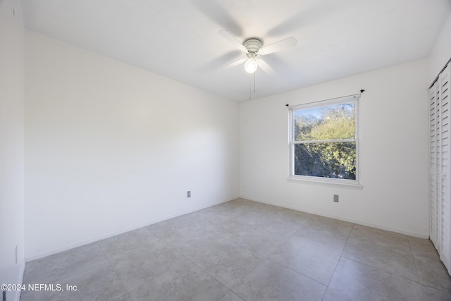 empty room with light tile patterned floors and ceiling fan