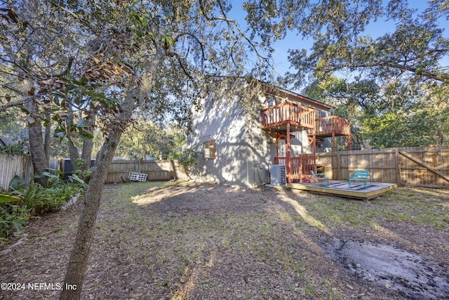 rear view of property with cooling unit and a deck