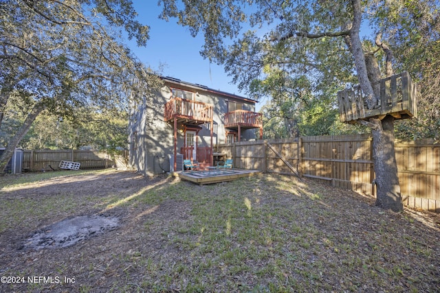 back of house with a lawn and a wooden deck