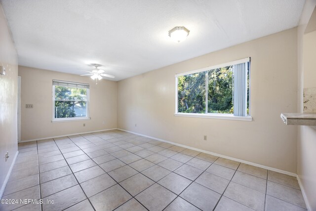 tiled spare room with ceiling fan