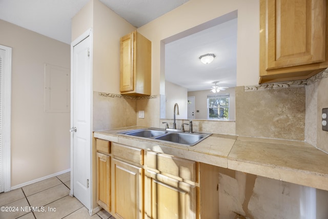 kitchen featuring light brown cabinetry, light tile patterned floors, ceiling fan, and sink