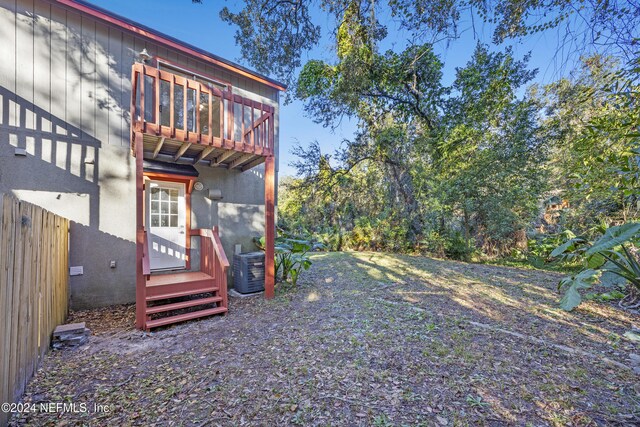 view of yard featuring a balcony and central AC