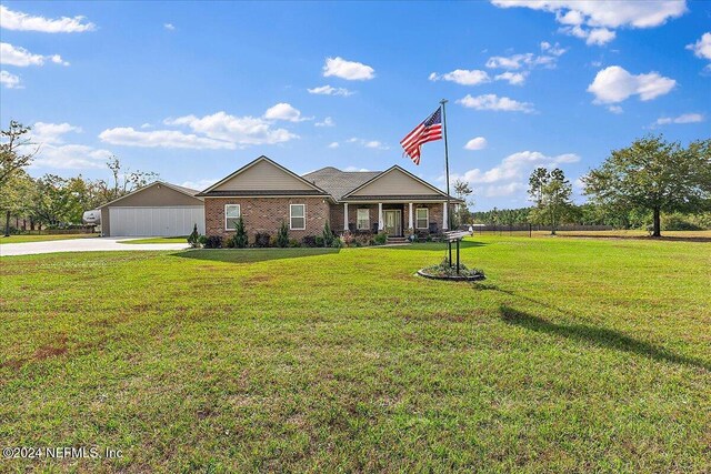 11018 Seneca Ln, Glen St Mary, FL 32040 - view of front of home with concrete driveway, a front yard, and a garage