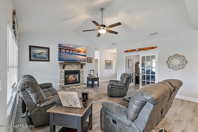 11018 Seneca Ln, Glen St Mary, FL 32040 - living room with a ceiling fan, wood finished floors, vaulted ceiling, a stone fireplace, and baseboards