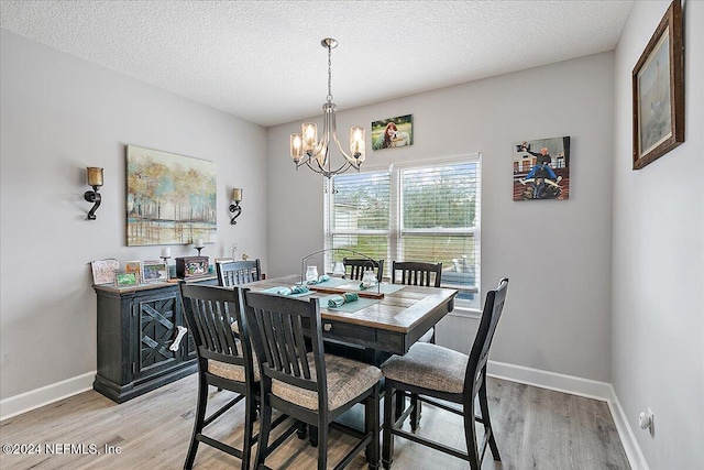 11018 Seneca Ln, Glen St Mary, FL 32040 - dining space featuring light wood finished floors, a chandelier, baseboards, and a textured ceiling