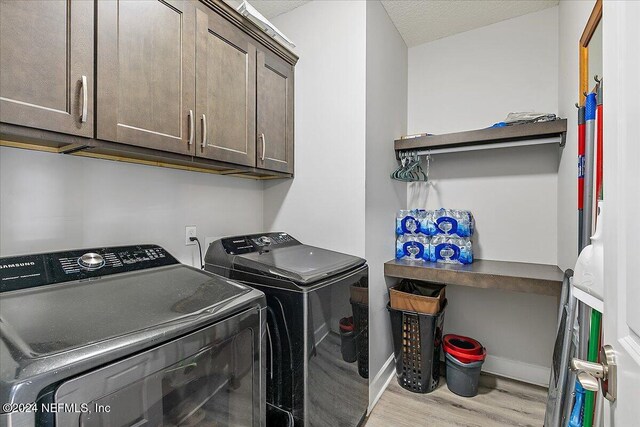 11018 Seneca Ln, Glen St Mary, FL 32040 - laundry room featuring washing machine and dryer, wood finished floors, cabinet space, and baseboards