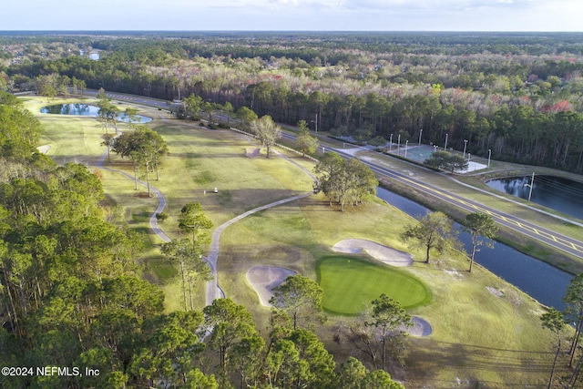 drone / aerial view featuring a water view, golf course view, and a wooded view