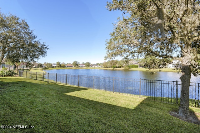 view of yard with a water view and fence