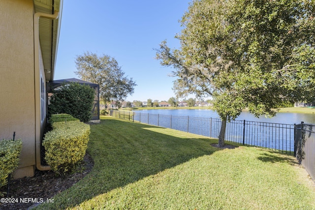 view of yard with a water view and a fenced backyard