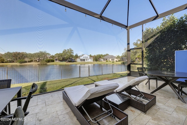 view of patio with outdoor dining area, a water view, and a fenced backyard