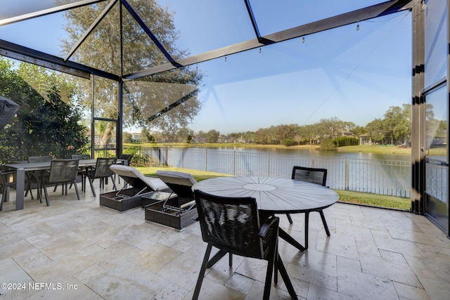 view of patio / terrace with a water view, fence, and outdoor dining space