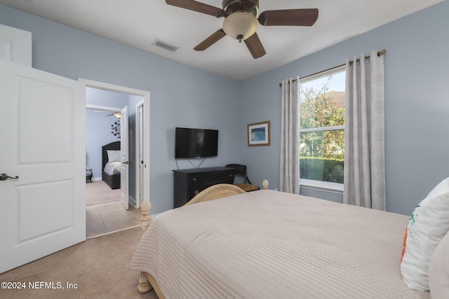 bedroom with a ceiling fan, light carpet, and visible vents