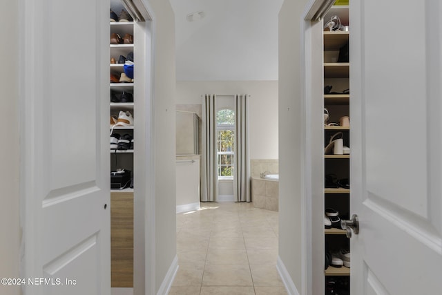 hallway with light tile patterned floors and baseboards