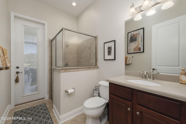 bathroom featuring tile patterned flooring, toilet, vanity, baseboards, and a stall shower