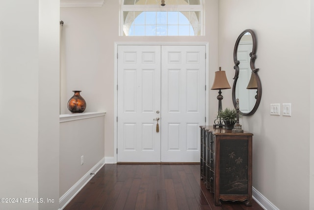 foyer featuring baseboards and dark wood finished floors