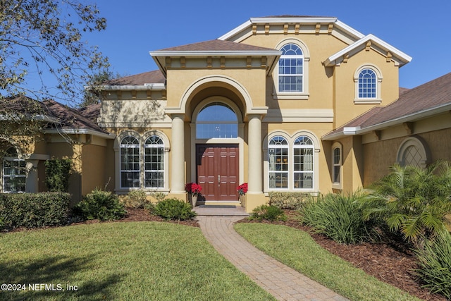 view of front facade featuring a front yard and stucco siding