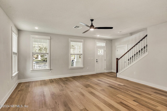 foyer featuring ceiling fan, a textured ceiling, and light hardwood / wood-style flooring