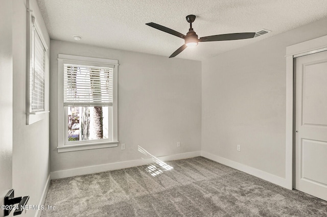 spare room featuring a textured ceiling, light colored carpet, and ceiling fan