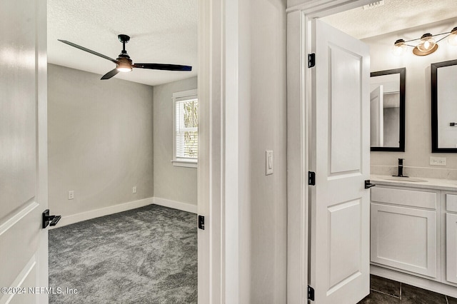 bathroom with ceiling fan, a textured ceiling, and vanity