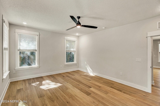 unfurnished room with ceiling fan, light hardwood / wood-style flooring, and a textured ceiling