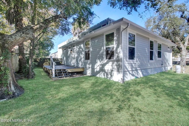 view of property exterior with a wooden deck and a yard