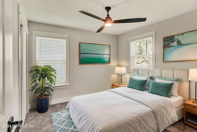 carpeted bedroom featuring a textured ceiling and ceiling fan