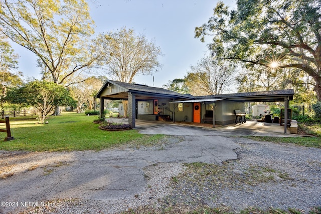 view of front of home with a front yard and a carport