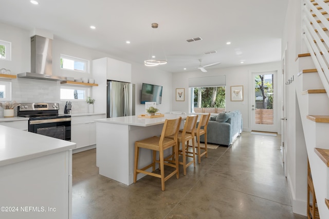 2 Sanchez Cv, Saint Augustine, FL 32080 - kitchen with appliances with stainless steel finishes, wall chimney exhaust hood, recessed lighting, concrete floors, and white cabinetry