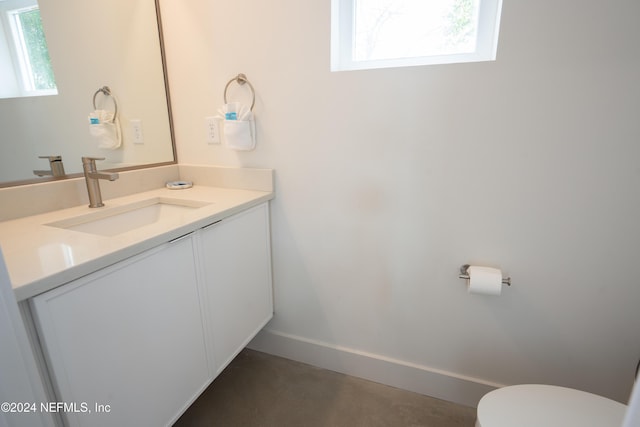 2 Sanchez Cv, Saint Augustine, FL 32080 - half bathroom featuring vanity, toilet, baseboards, and finished concrete flooring