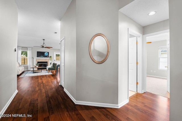 hallway with wood-type flooring and a textured ceiling