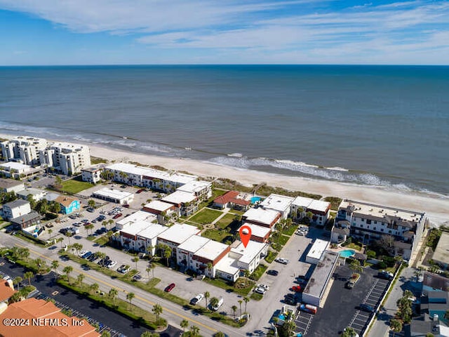 birds eye view of property with a water view and a beach view