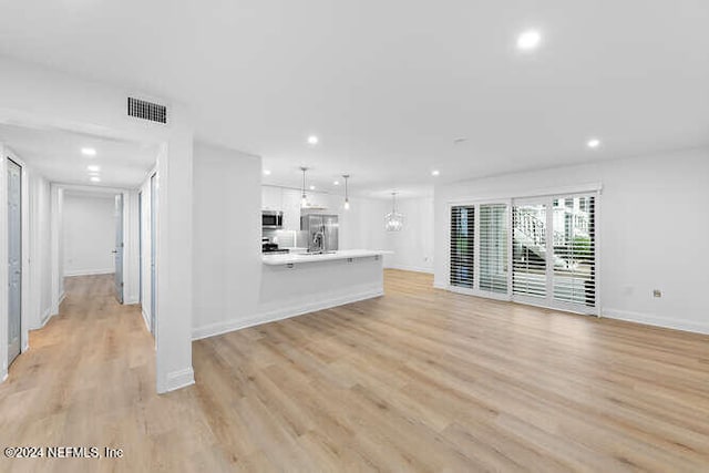 unfurnished living room with light wood-type flooring