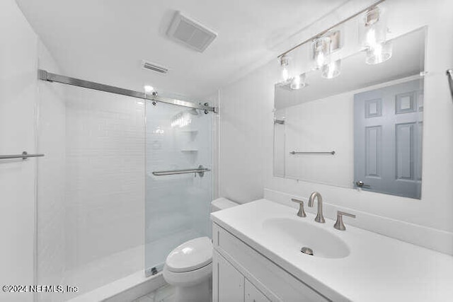 bathroom with a shower with door, vanity, and toilet