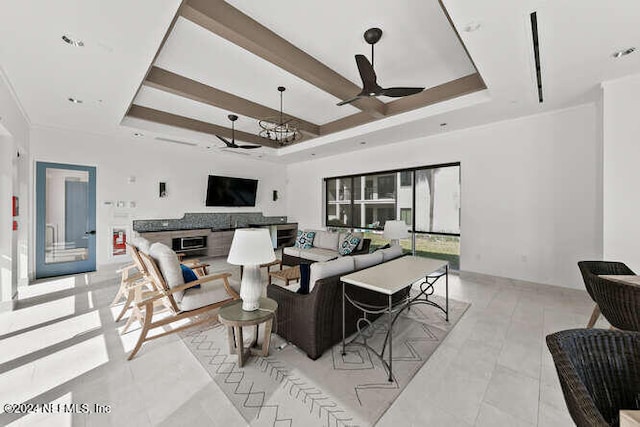 living room featuring a tray ceiling, ceiling fan, and light tile patterned flooring