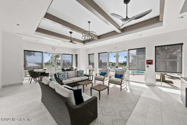 interior space featuring ceiling fan, a healthy amount of sunlight, light tile patterned floors, and a tray ceiling