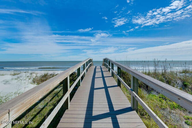 view of dock featuring a water view and a view of the beach