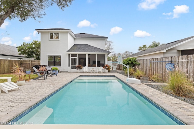 back of house featuring a fenced in pool, a patio area, and a sunroom