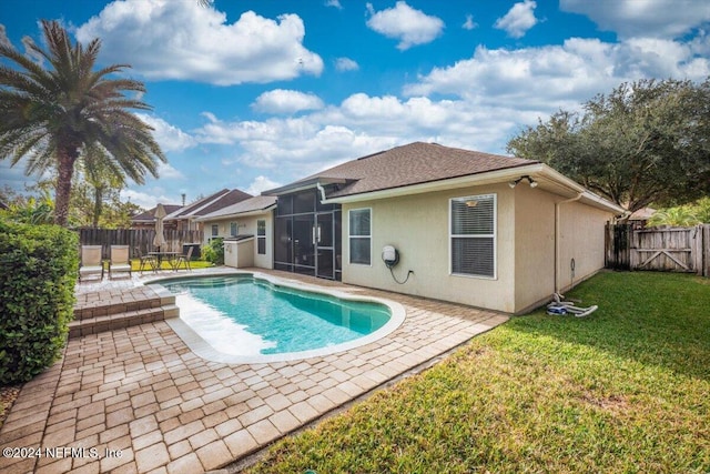 view of pool with a lawn, a sunroom, and a patio area