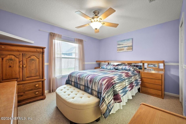 carpeted bedroom with a textured ceiling and ceiling fan