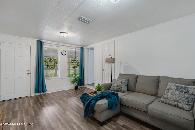 living room with hardwood / wood-style floors and crown molding