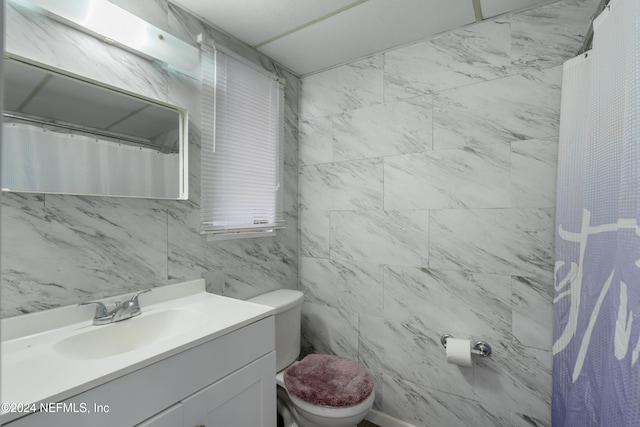 bathroom featuring walk in shower, vanity, toilet, and tile walls