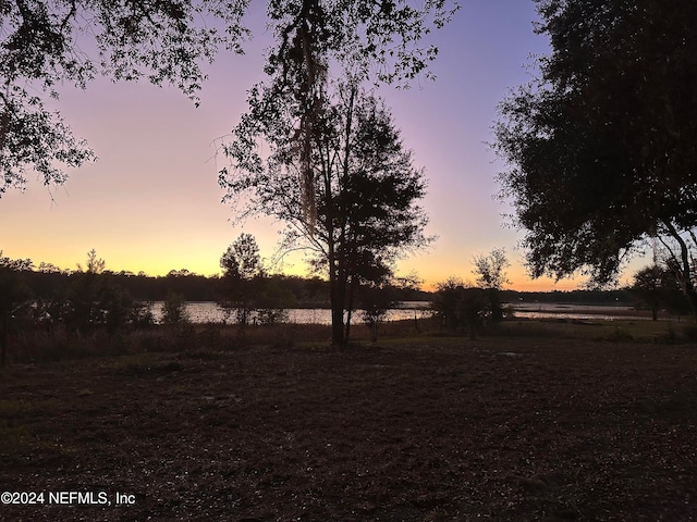 yard at dusk featuring a rural view