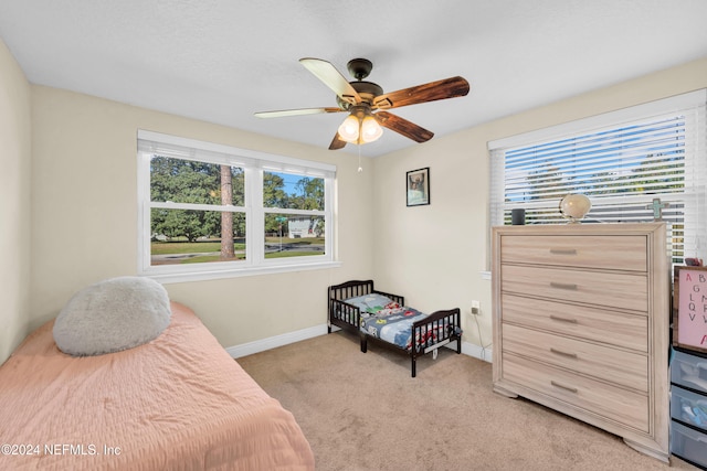 carpeted bedroom with multiple windows and ceiling fan