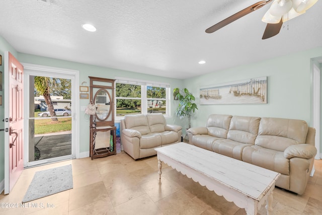 living room featuring a textured ceiling, a wealth of natural light, and ceiling fan