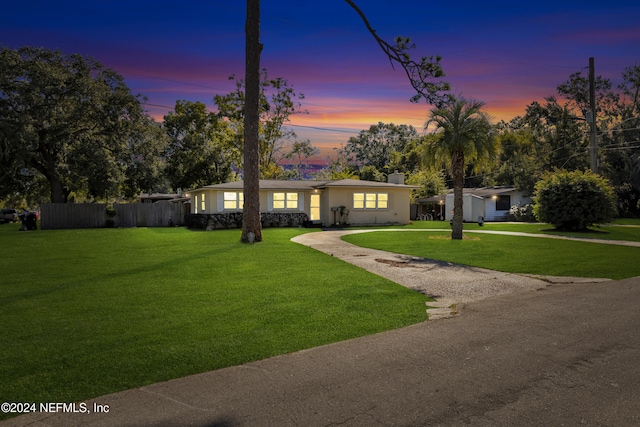 single story home featuring a lawn