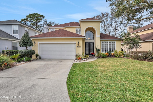 view of front of house featuring a garage, a front yard, and french doors