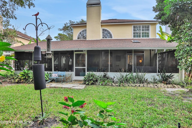 rear view of house with a lawn and a sunroom