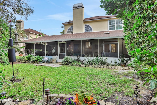 rear view of house featuring a sunroom and a yard