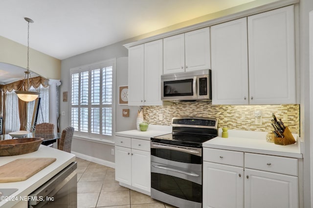 kitchen with decorative backsplash, white cabinetry, decorative light fixtures, and appliances with stainless steel finishes